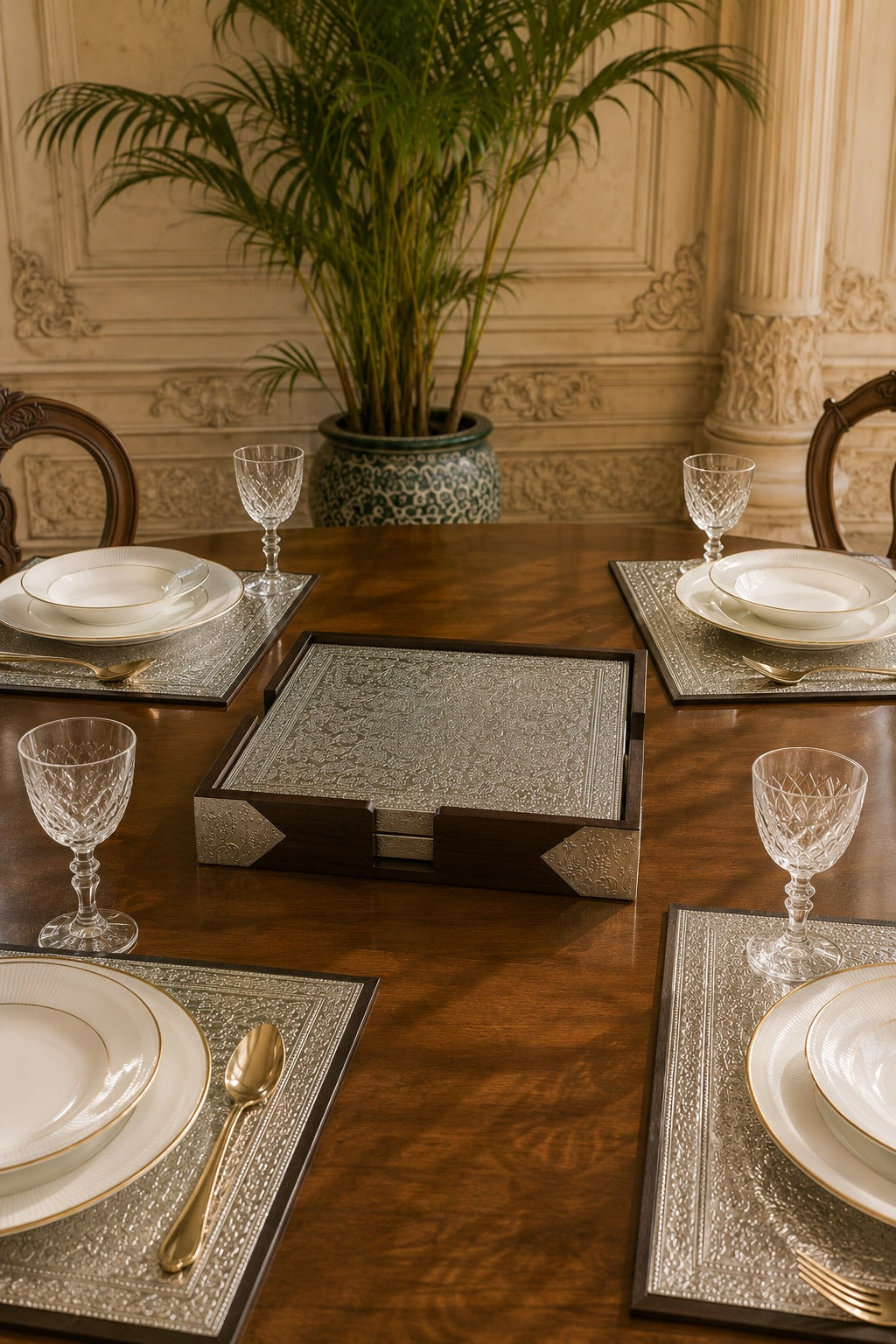 Dining table set with plates, glasses, and silverware in a formal setting.