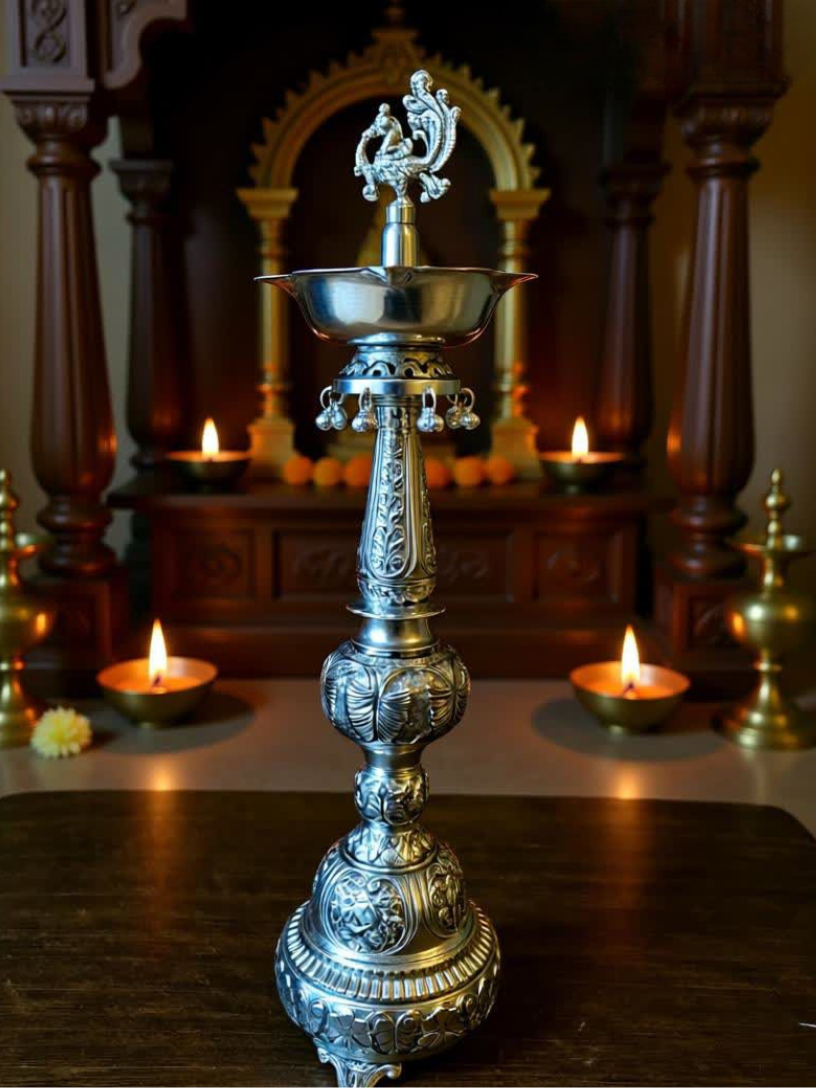 Decorative silver lamp with candles in the background